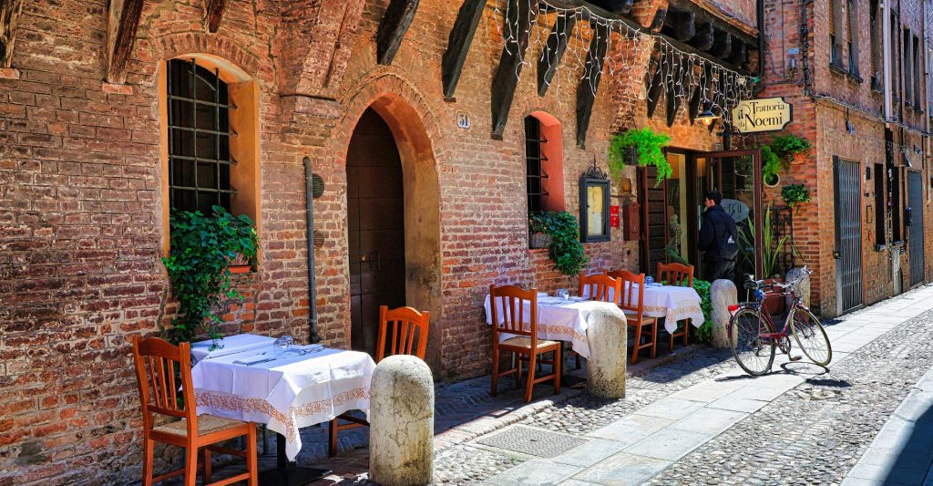 Imagen de unos restaurantes encantadores en una calle de Italia
