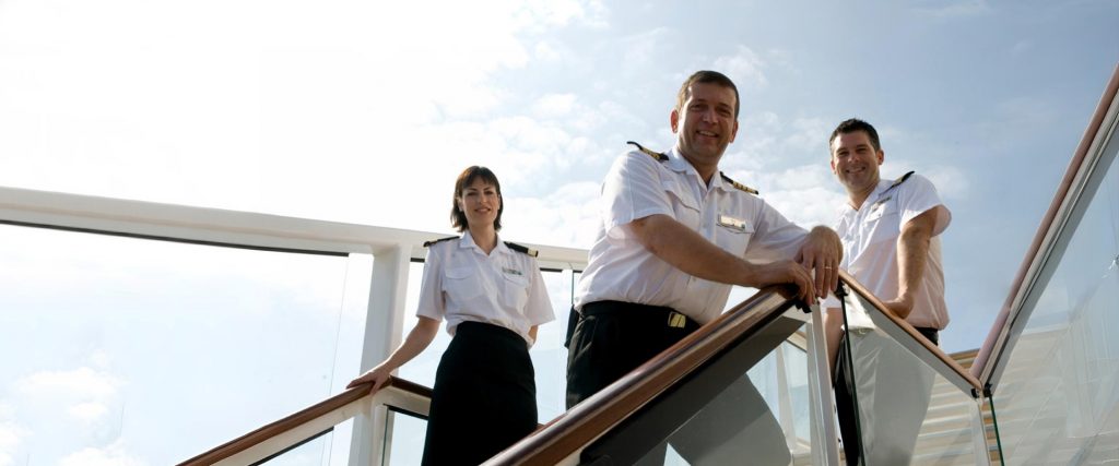 Imagen de un equipo de tripulantes y capitanes de un barco de crucero de la naviera Celebrity.