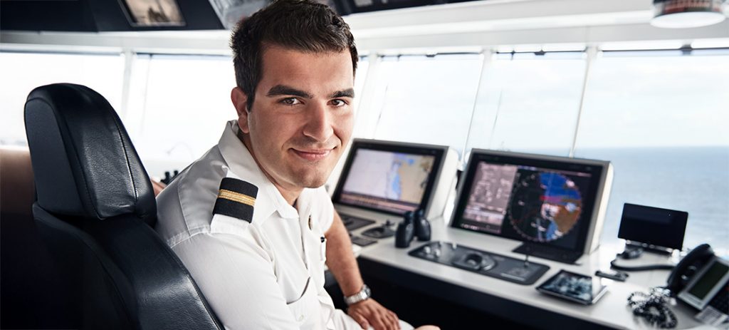 Un hombre trabajando en la sala de control de un crucero Imagen de primer plano de un hombre trabajando en la sala de control de un crucero con el mar de fondo