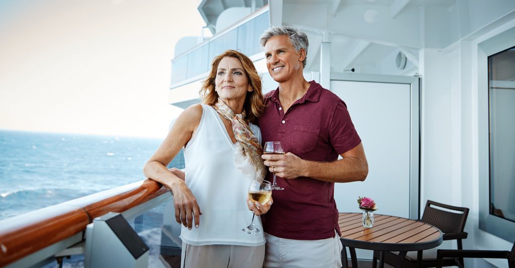 Una pareja disfruta de unas copas a bordo de su suite en un crucero Imagen de una pareja disfrutando de unas copas de vino a bordo de su suite en un crucero
