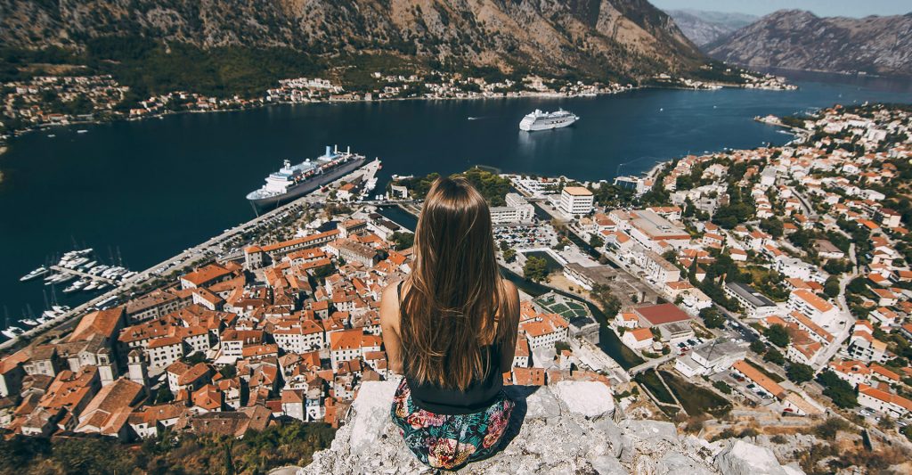 Una mujer observando las vistas de Kotor en su escala de crucero cultural por el Mediterráneo Imagen de una mujer en un mirador observando las vistas a la ciudad de Kotor en su escala de crucero cultural por el Mediterráneo