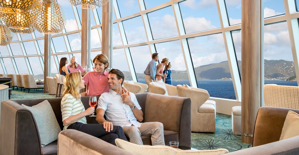 Familia en el Observation Lounge de un crucero NCL Guía de Expertos: Imagen de una familia disfrutando en el Observation Lounge a bordo de un crucero NCL
