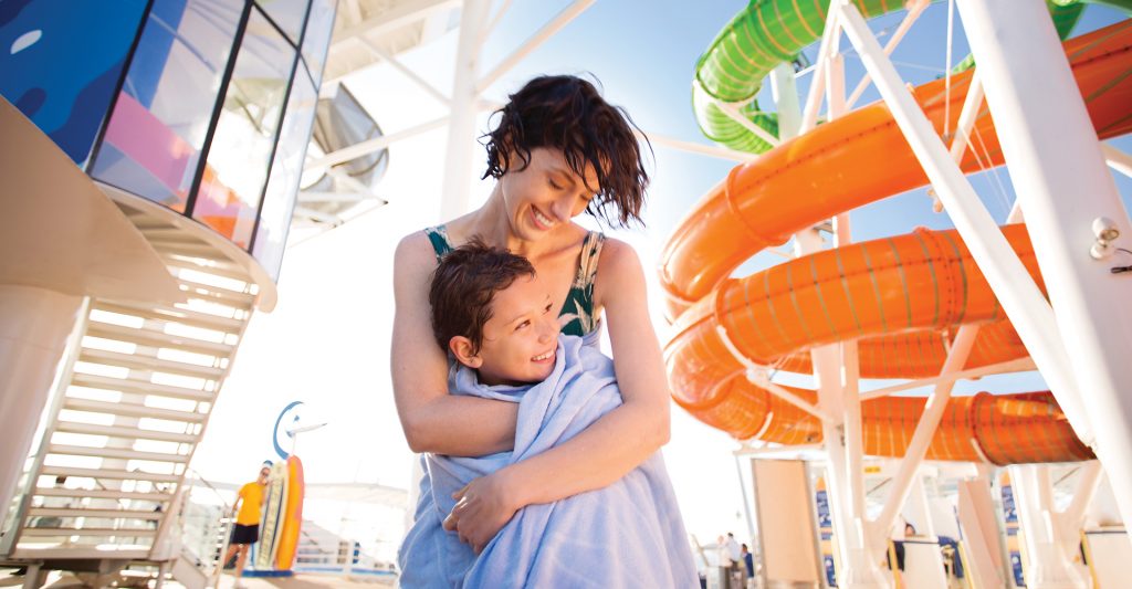 Reservar con agencia especializada en cruceros: Imagen de una madre y su hijo en la zona de piscinas de un barco Royal Caribbean