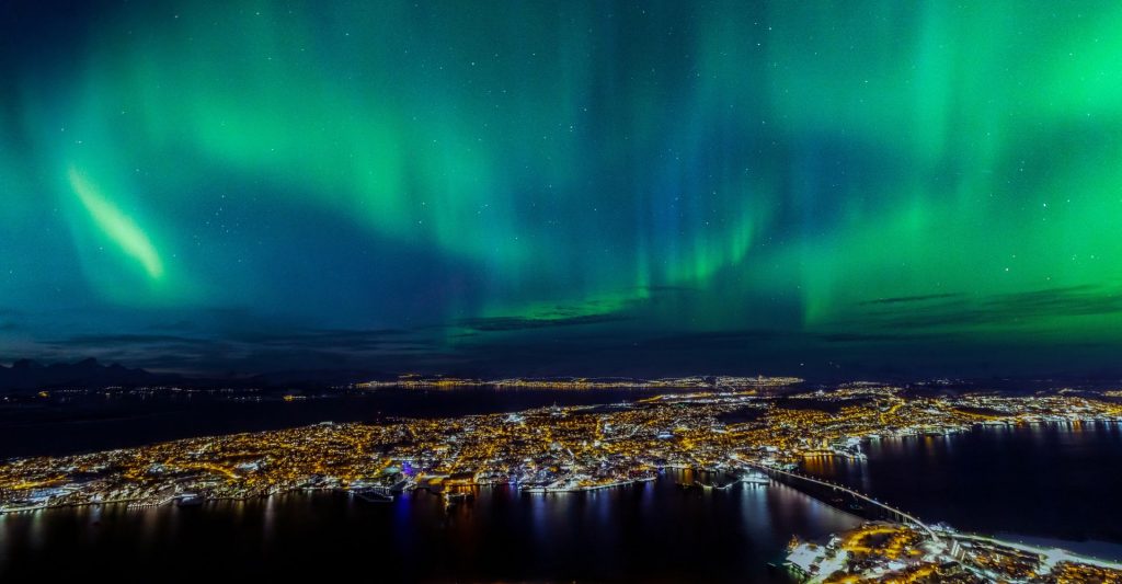 Espectáculo de auroras boreales visto desde la cubierta de un barco en un crucero por Noruega.