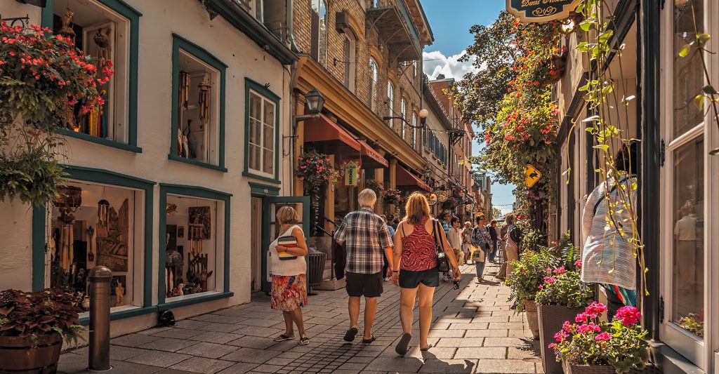 Imagen de varias personas paseando, en un día soleado, por las calles del Viejo Quebec en Canadá