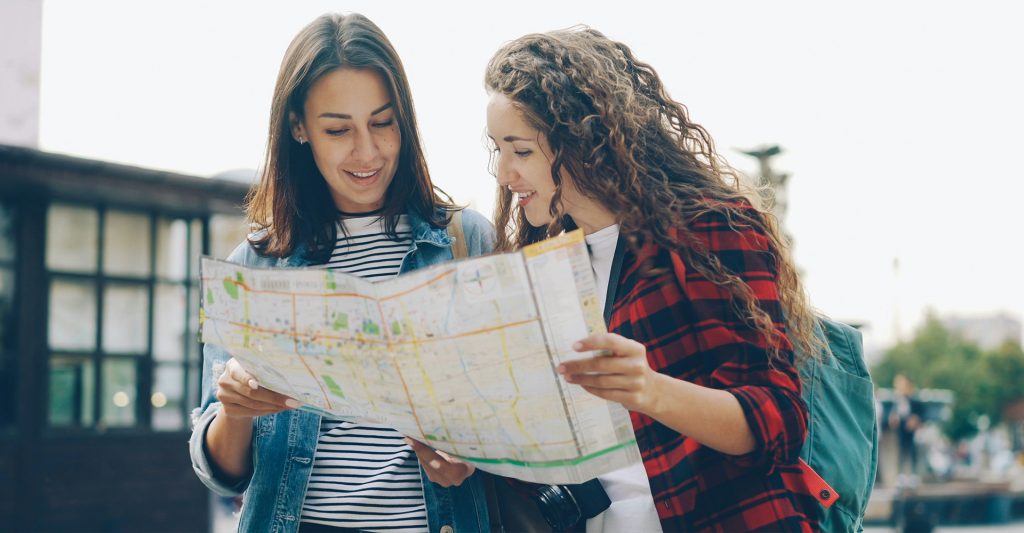 Imagen de dos amigas revisando el mapa en su escala de crucero en Génova