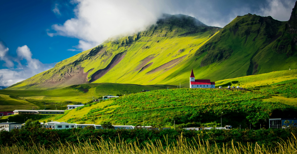 Fotografía de montañas y una iglesia en Islandia, destino perfecto para hacer un Crucero