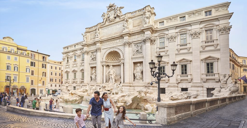 Fotografía de una familia divirtiéndose en la fuente de Trevi, destino de crucero