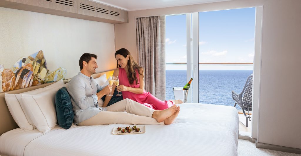 Crucero Todo Incluido: Imagen de una pareja brindando en su camarote, disfrutando de un crucero romántico, a bordo de un barco NCL 