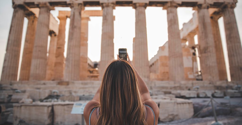 Imagen de una mujer en Atenas haciendo una foto del Acropolis en su escala de crucero por el Mediterráneo
