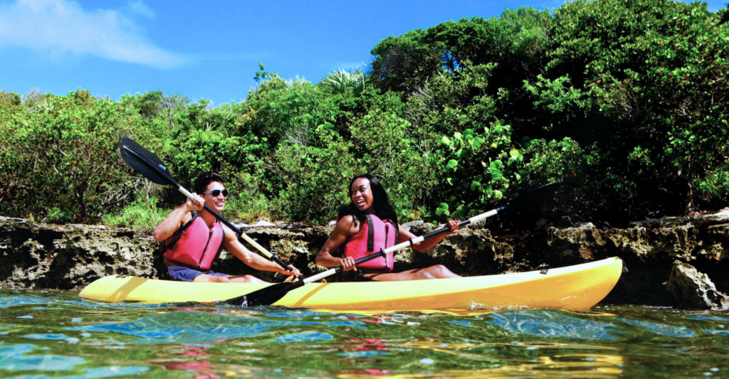 Pareja haciendo kayak en una isla privada, destino de crucero Fotografía de una pareja haciendo kayak en la isla privada Great Stirrup Cay, destino de crucero