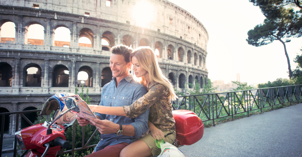 Fotografía de una pareja en una moto mirando un mapa en roma, destino de crucero