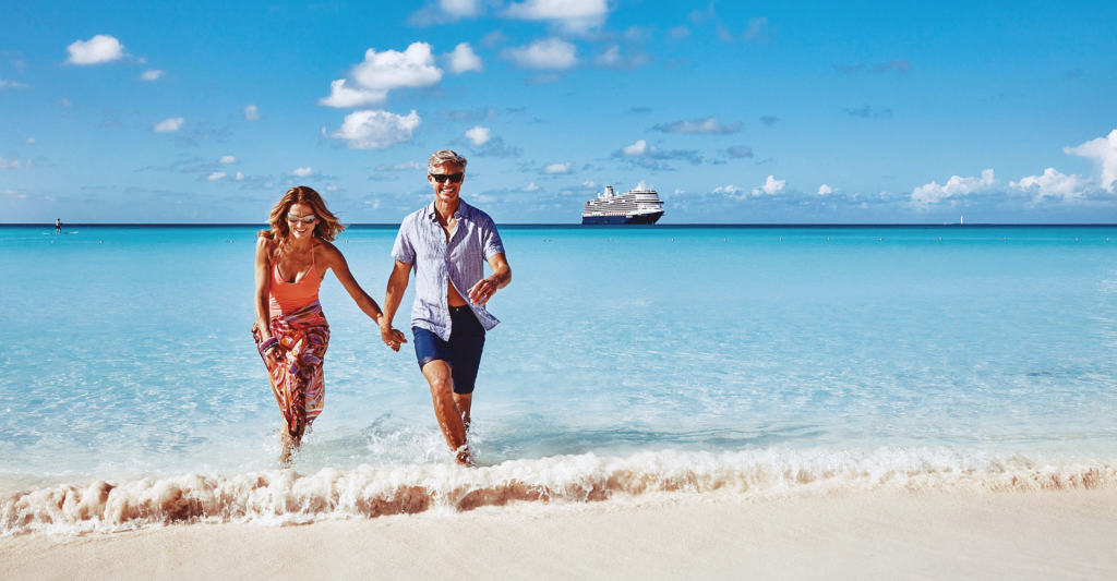 Pareja en una playa en Half Moon Cay, isla privada, destino crucero Fotografía de una pareja en una playa en la isla privada Half Moon Cay, destino de crucero