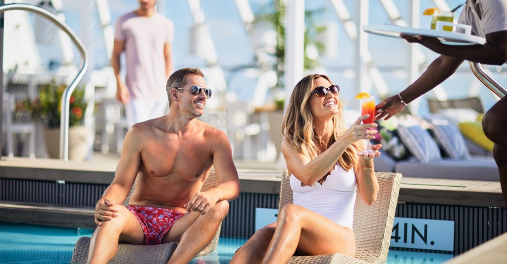 Imagen de una pareja tomando un cocktail en una piscina de un crucero de la naviera Celebrity Cruises