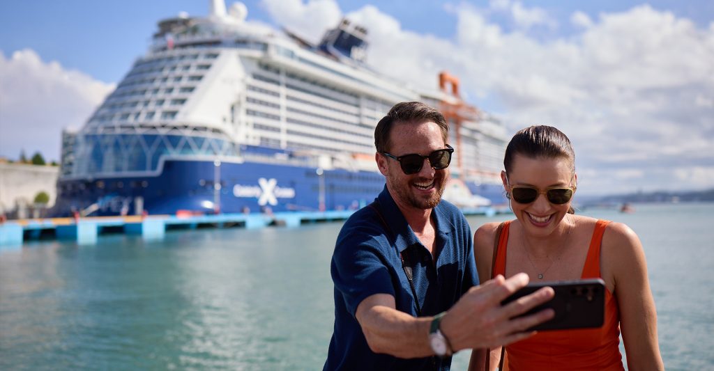 Una pareja con su crucero Celebrity de fondo en su puerto de escala Una pareja se hace una selfie con su crucero Celebrity de fondo en su puerto de escala