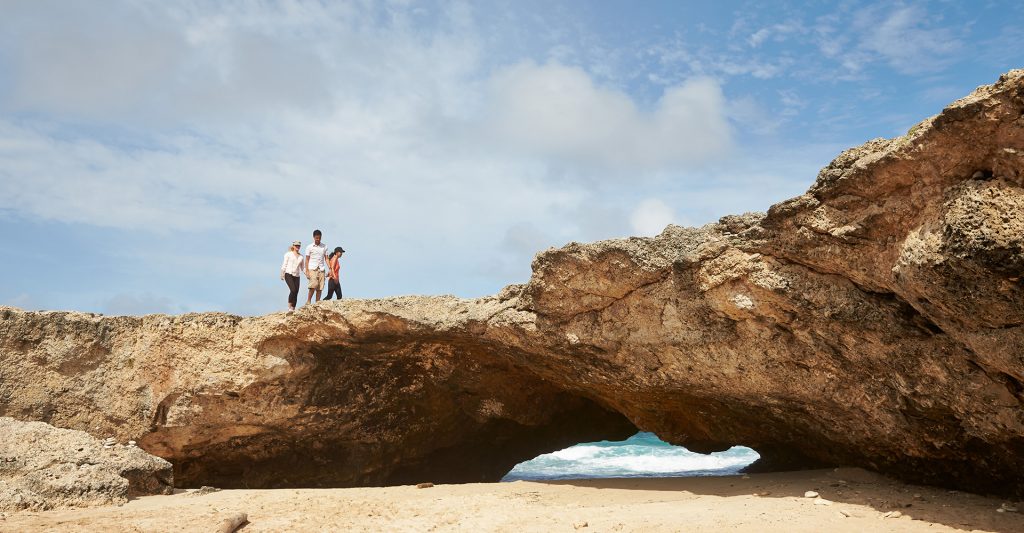 Imagen de una familia explorando formaciones rocosas en Aruba durante una escala de crucero