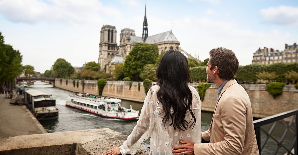 Imagen de una pareja contemplando la catedral de Notre Dame y el río Sena durante una escala de crucero en París