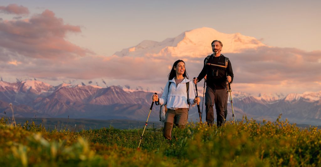 Imagen de una pareja haciendo senderismo en un paisaje de montaña durante una escala de crucero