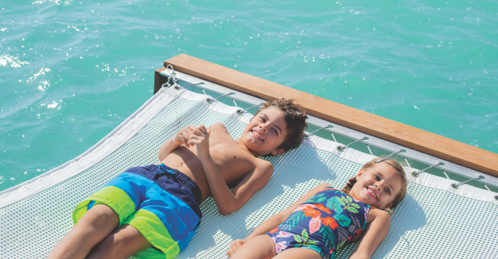 Unos niños tumbados en las Bahamas, aprovechando su escala de cruceros Imagen de unos niños tumbados en una red sobre el mar en las Bahamas, aprovechando su escala de cruceros