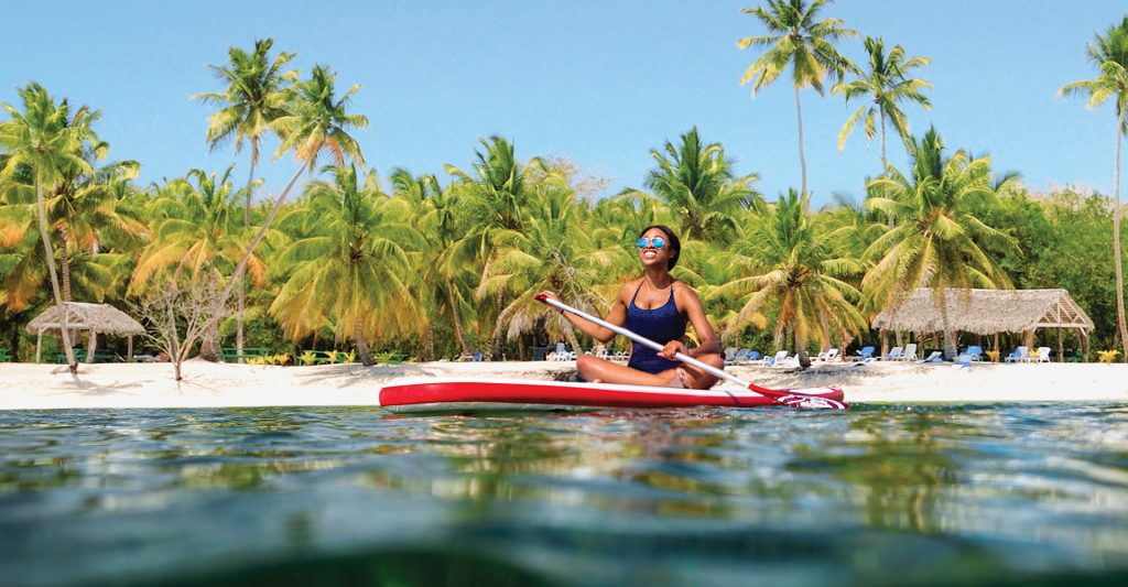 Imagen de una mujer haciendo Kayak en el mar, en su escala de crucero en el Caribe