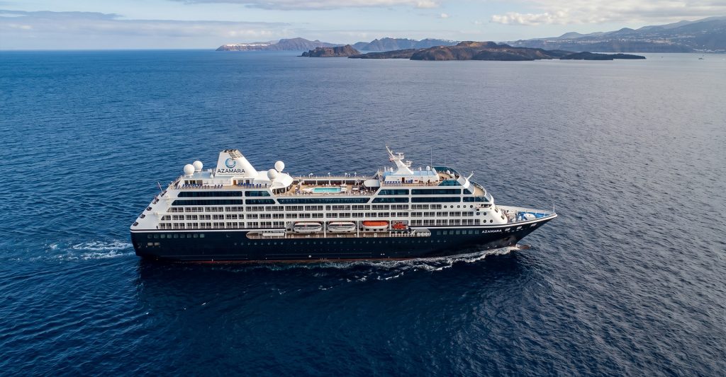 Crucero Azamara navegando en alta mar junto a una costa montañosa