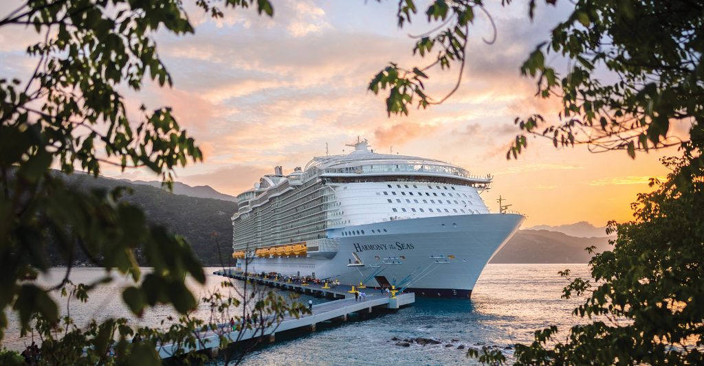 Impresionante barco de crucero Royal Caribbean amarrado en un muelle al atardecer.