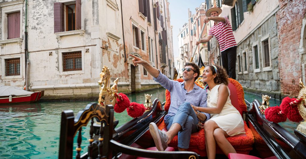 Recorrer Venecia en góndola, una experiencia imprescindible en cualquier crucero por Italia Pareja disfrutando de un paseo en góndola por los canales de Venecia durante una escala de crucero