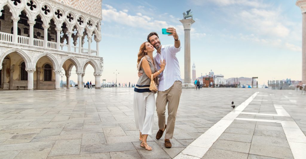 La Plaza de San Marcos, uno de los lugares más icónicos de Venecia para los viajeros de crucero Pareja haciéndose una foto en la Plaza de San Marcos durante una visita a Venecia en crucero