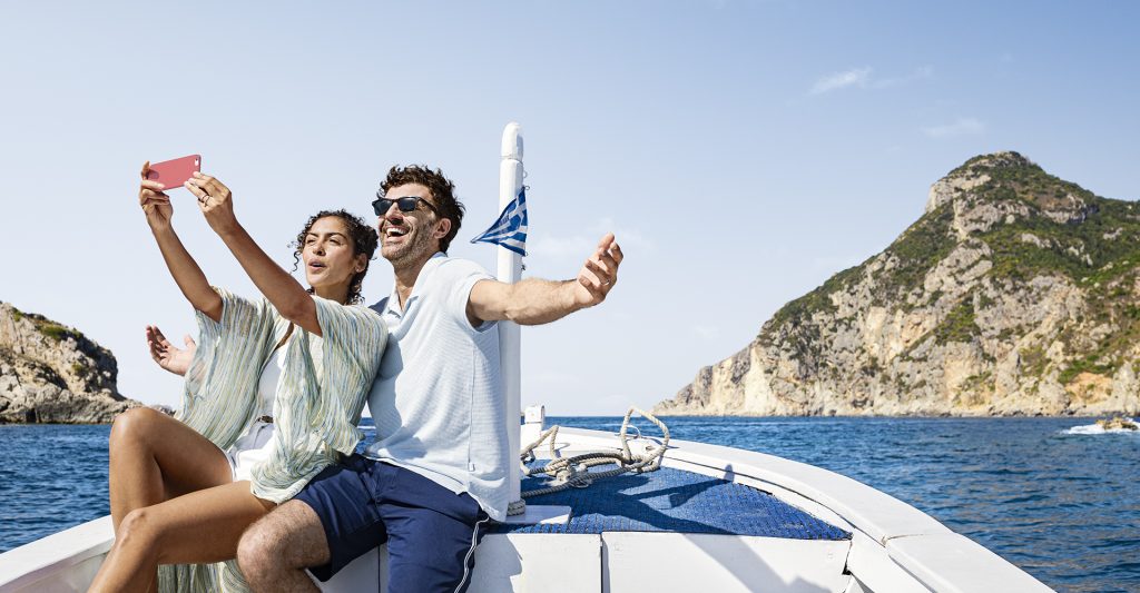 Excursión en barco en Corfú durante un crucero por las Islas Griegas Pareja disfrutando de una excursión en barco frente a la costa de Corfú durante un crucero por las Islas Griegas