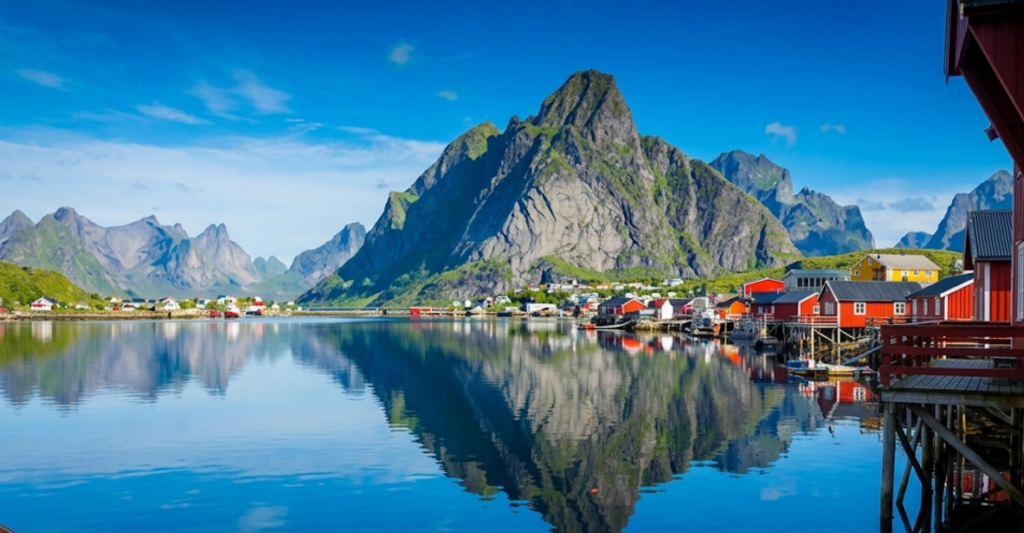 Destinos pintorescos y naturaleza en los cruceros bálticos. Paisaje idílico de casitas rojas de pescadores reflejadas en el agua con montañas de fondo en el Norte de Europa.