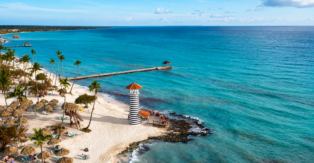Viaje de fin de curso al Caribe Playa de aguas turquesas con palmeras y faro en el Caribe