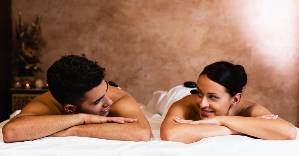 Experiencia de masaje en pareja con piedras calientes en spa Pareja disfrutando de un masaje relajante con piedras calientes en la espalda en un centro de spa