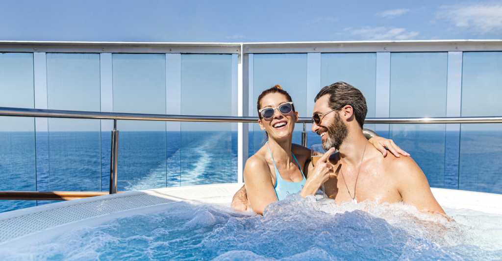 Pareja relajándose en jacuzzi con vistas al mar en un crucero