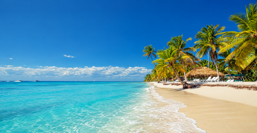 Playa de arena blanca, palmeras y aguas turquesas en el Caribe
